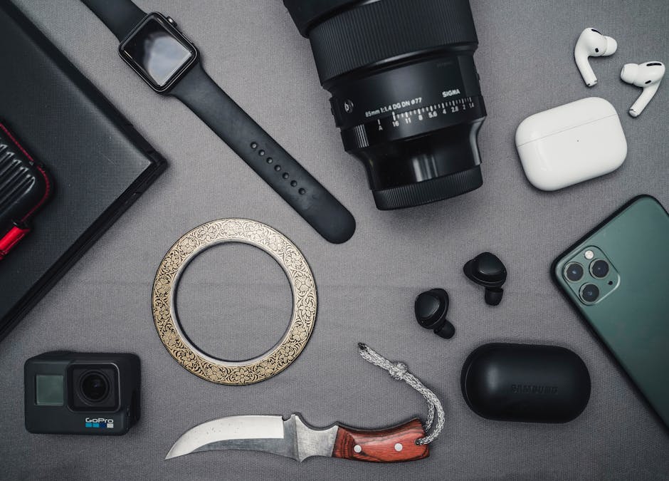 Flat lay of tech gadgets and personal accessories including camera and smartwatch.