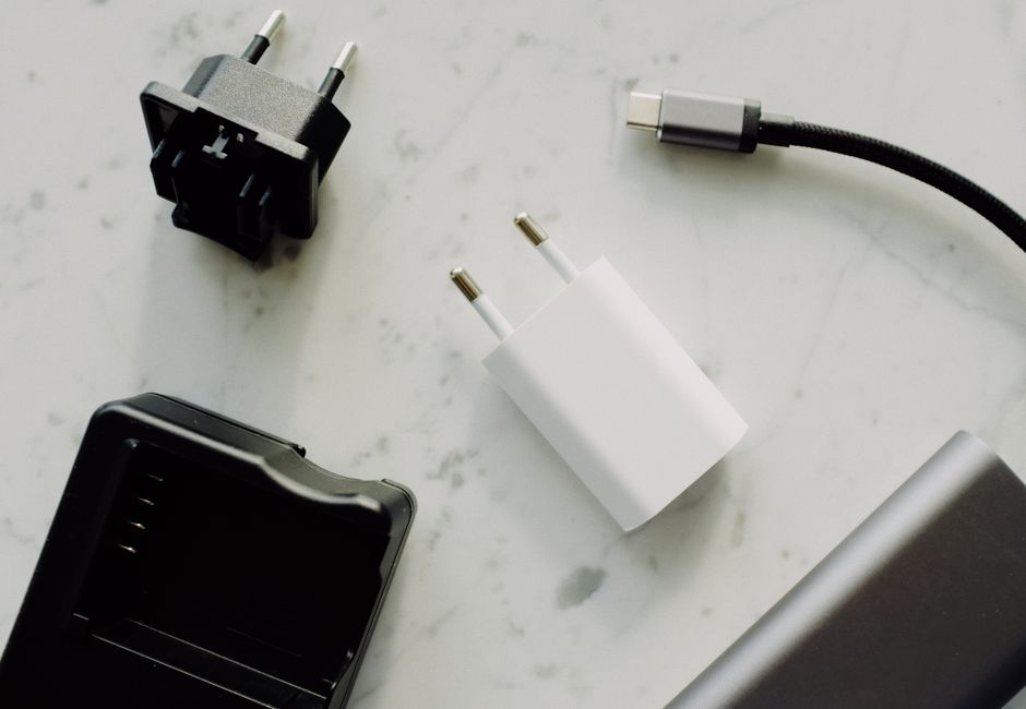Close-up of USB-C and adaptors on a marble surface, highlighting modern electronics essentials.