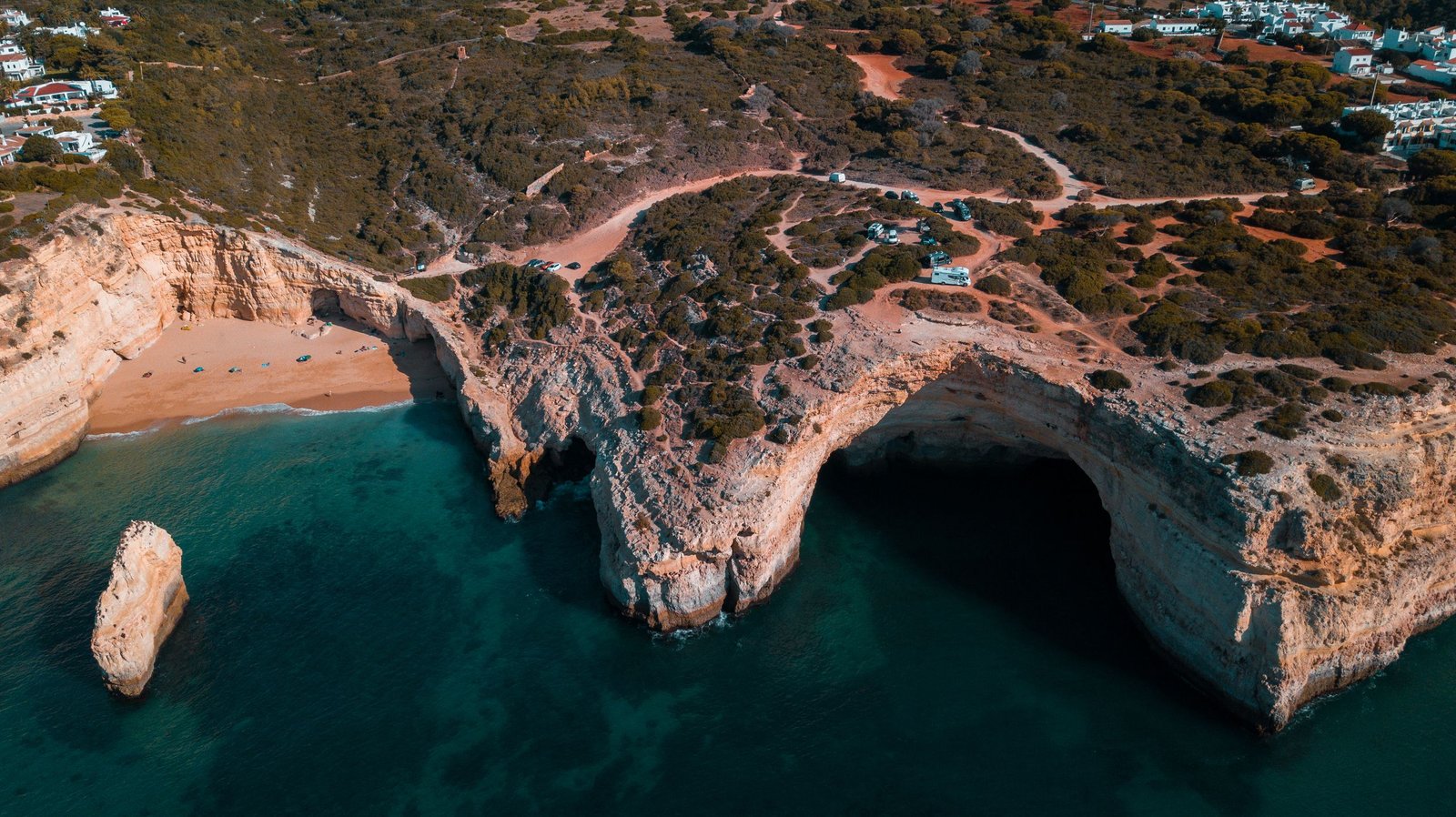 Cueva y acantilados del Algarve portugués con agua cristalina azul