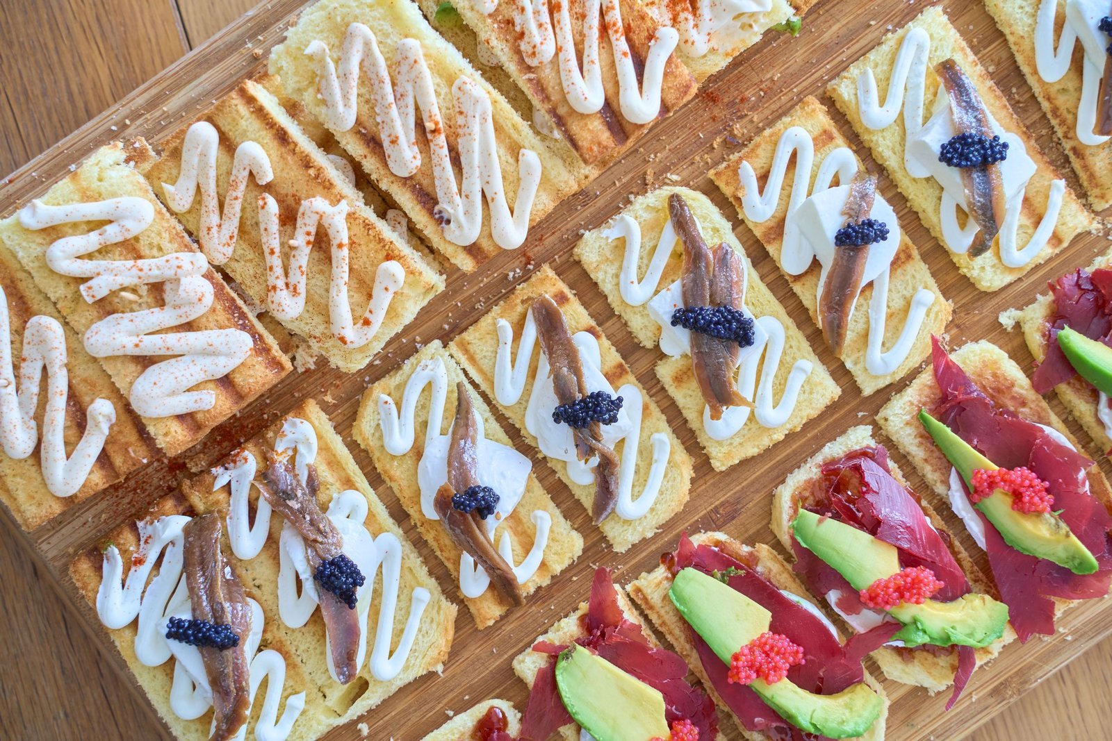 Selección de pintxos gourmet vascos con anchoas queso y aguacate en barra