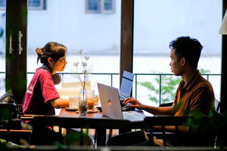 Persona trabajando con ordenador portátil en cafetería de Vietnam usando conexión WiFi