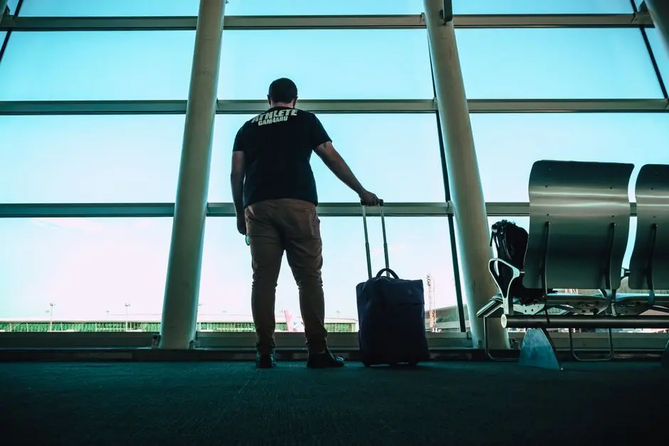 Viajero esperando su maleta en la sala de llegadas del aeropuerto