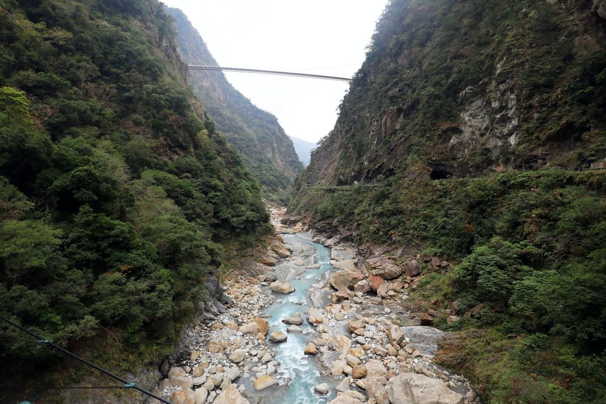 Puente colgante sobre el río en el desfiladero de Taroko entre montañas verdes