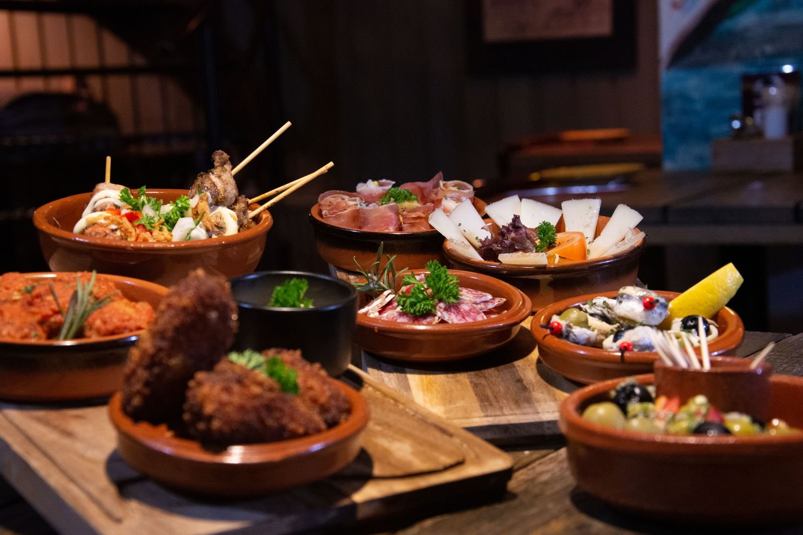 Variedad de tapas españolas servidas en una barra de bar