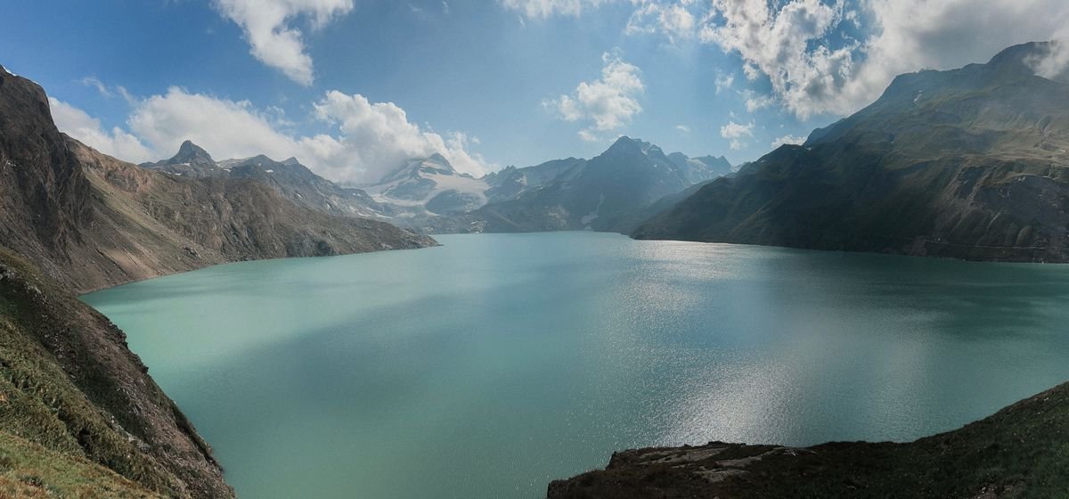 Lago de montaña turquesa rodeado de picos alpinos en Suiza