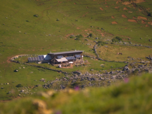 Cabaña sostenible con paneles solares en medio de un vasto paisaje natural