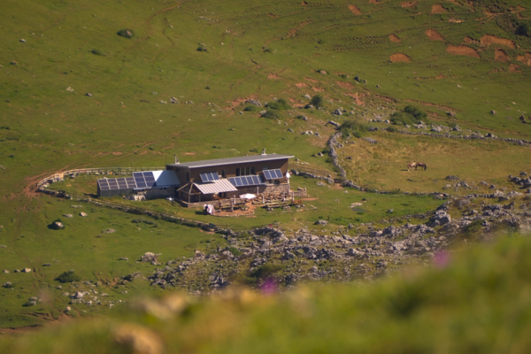 Cabaña sostenible con paneles solares en medio de un vasto paisaje natural