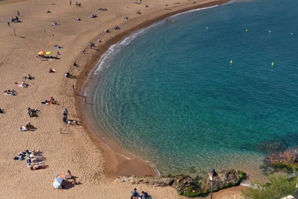 Vista aérea de la playa de Barcelona en verano con turistas disfrutando del mar Mediterráneo