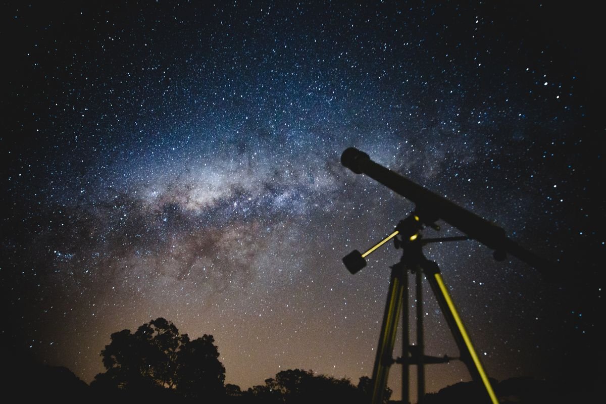 Telescopio apuntando a la Vía Láctea en una noche estrellada