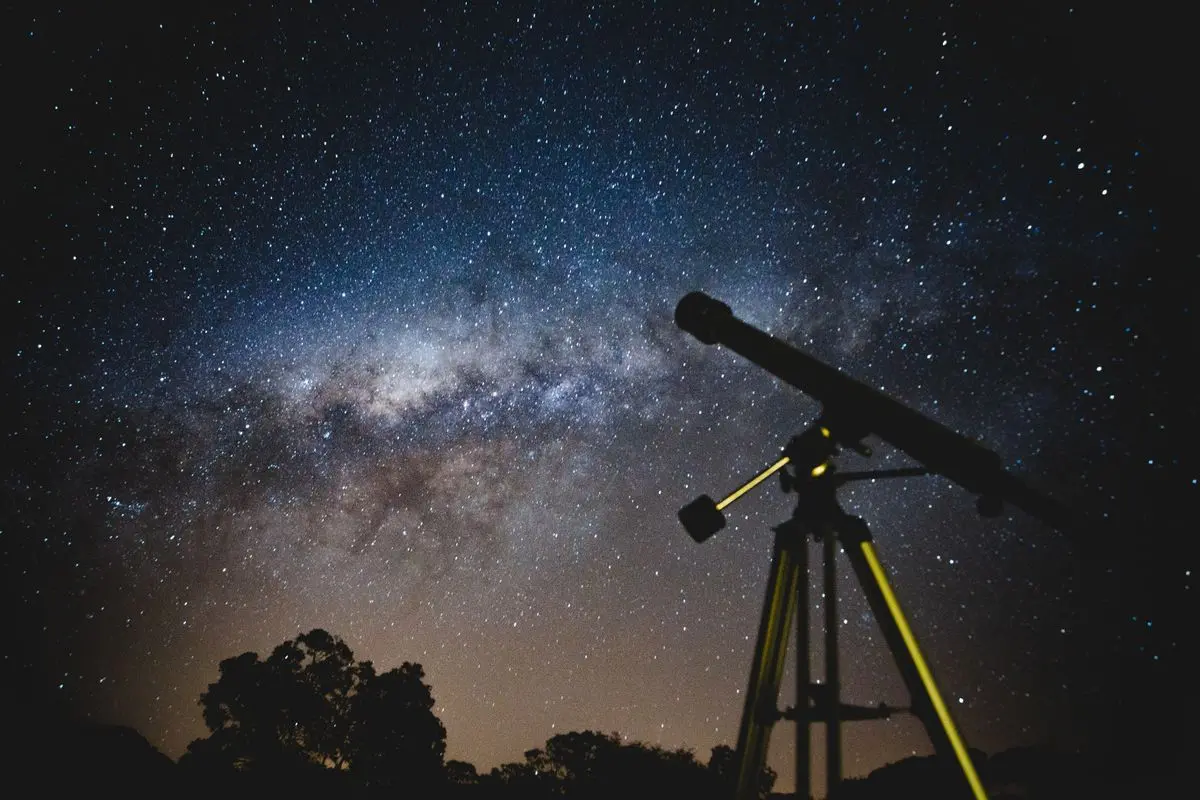 Telescopio apuntando a la Vía Láctea en una noche estrellada