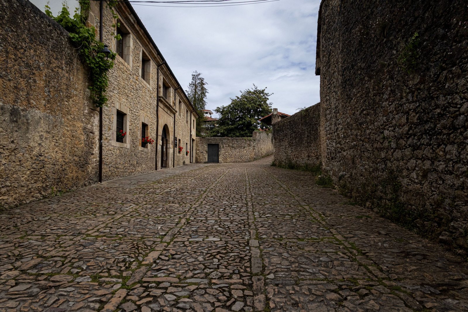 Calle empedrada de pueblo medieval con edificios de piedra