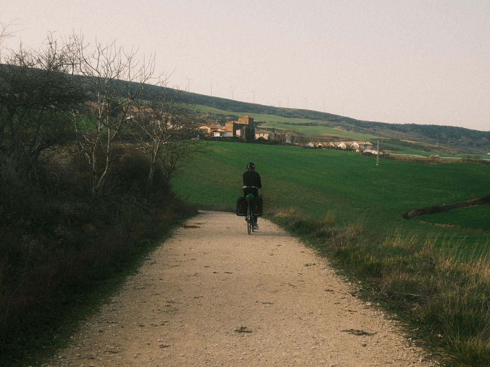 Ciclista recorriendo un camino rural cerca de Pamplona, similar a las vías verdes españolas