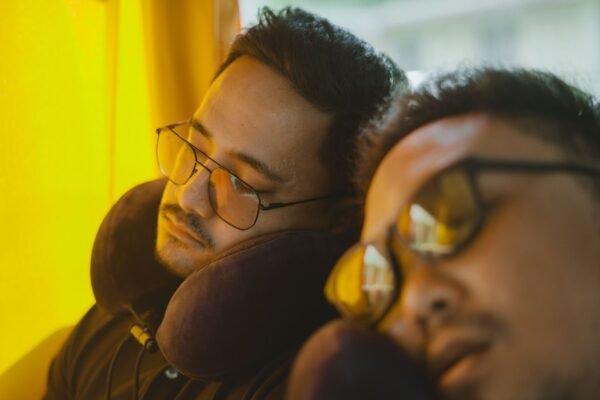 Dos viajeros durmiendo en autobús con almohadas cervicales