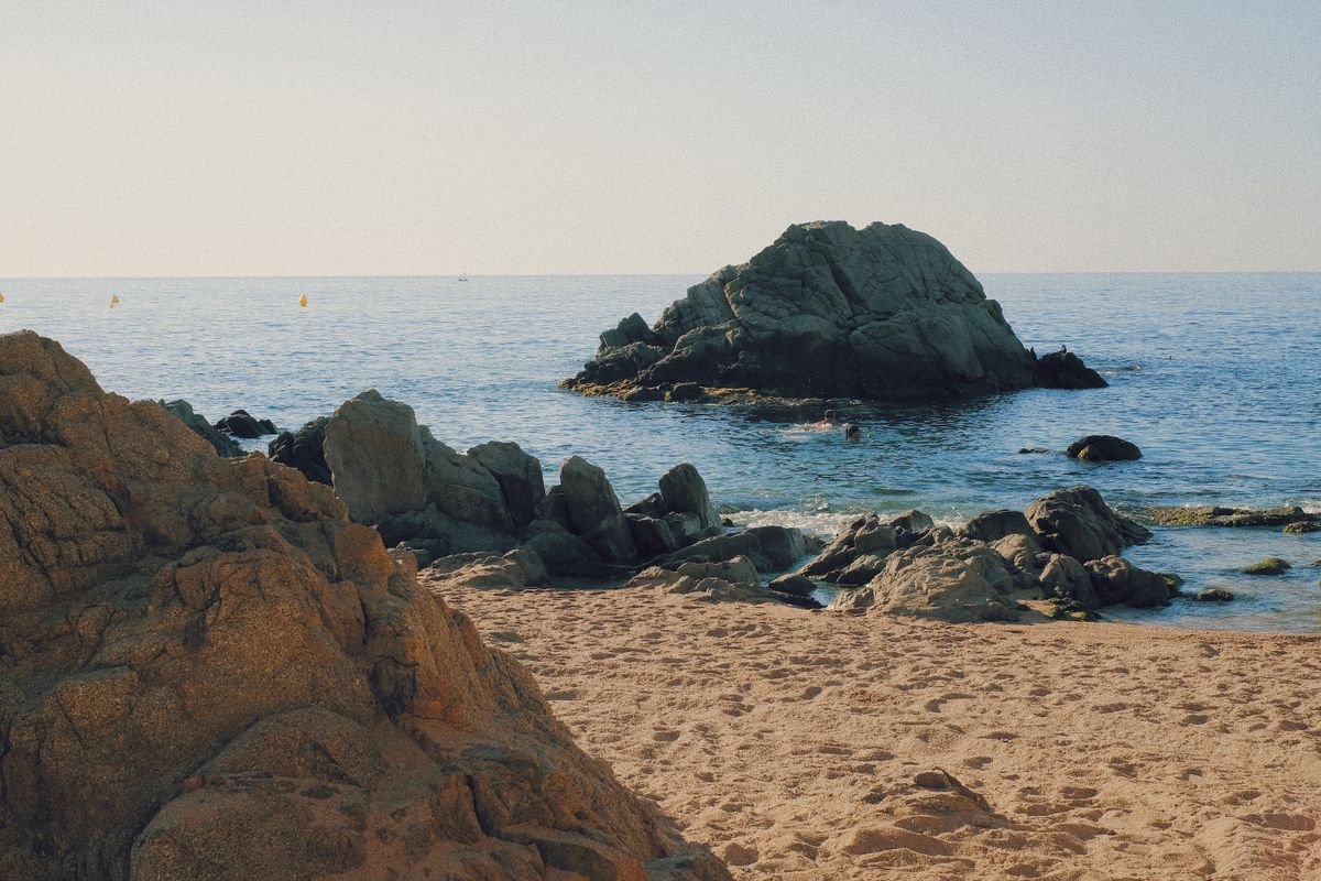 Cala de aguas cristalinas en la Costa Brava con paisaje mediterráneo