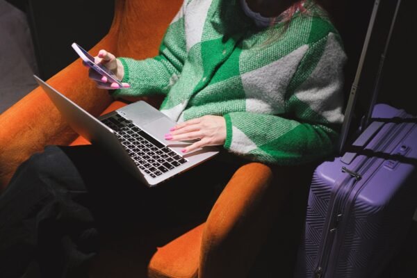 Mujer trabajando con portátil y móvil como nómada digital