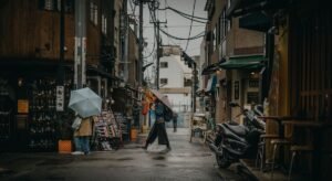 Personas con paraguas caminando bajo la lluvia en una calle urbana