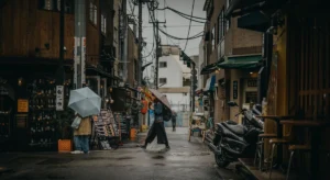 Personas con paraguas caminando bajo la lluvia en una calle urbana