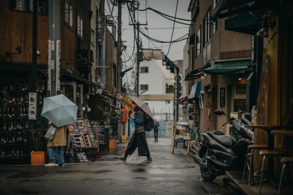Personas con paraguas caminando bajo la lluvia en una calle urbana