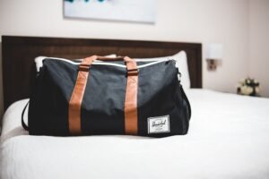 Bolsa de viaje weekender preparada sobre la cama de un hotel para una escapada