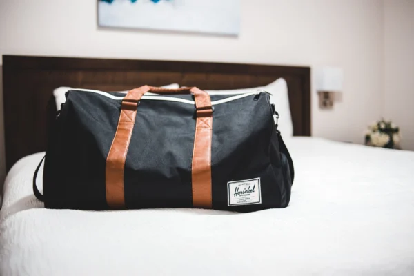 Bolsa de viaje weekender preparada sobre la cama de un hotel para una escapada