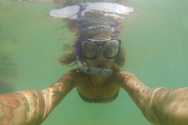 Cámara de acción grabando un selfie bajo el agua durante una sesión de snorkel en un arrecife de coral