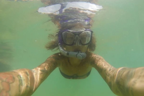 Cámara de acción grabando un selfie bajo el agua durante una sesión de snorkel en un arrecife de coral