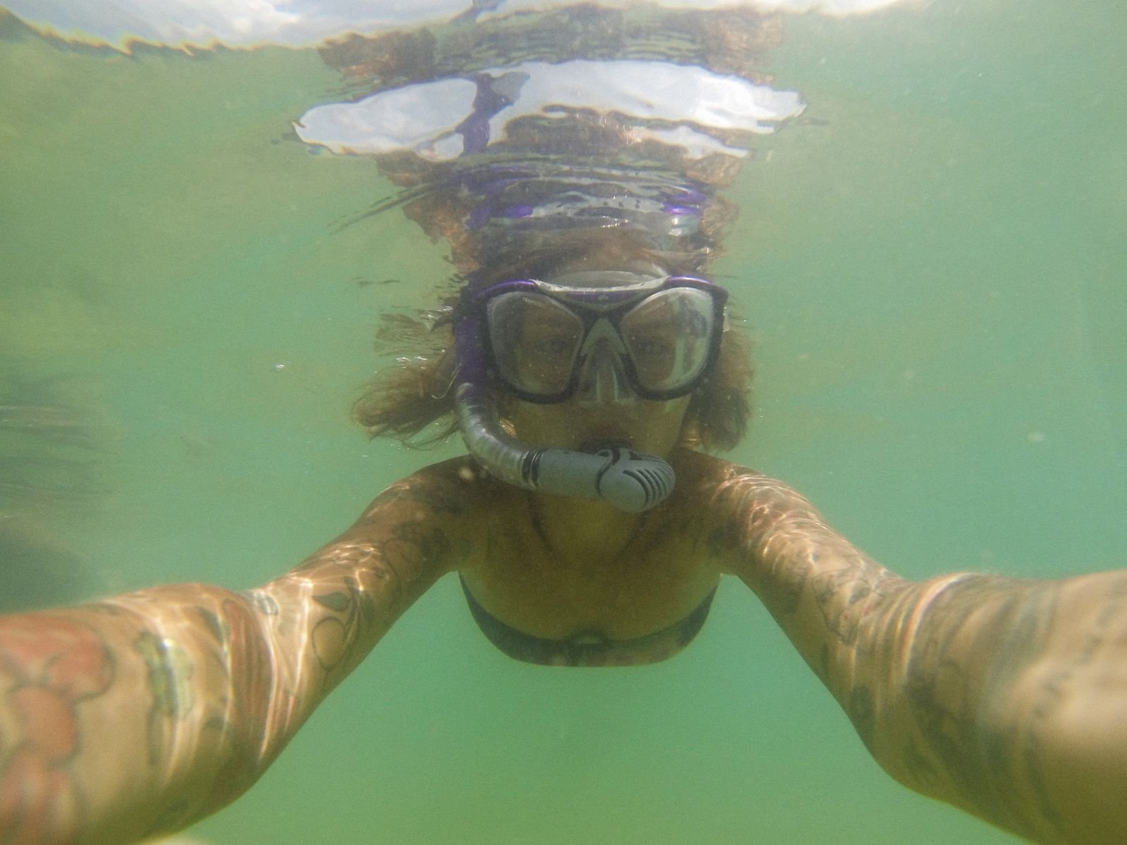 Cámara de acción grabando un selfie bajo el agua durante una sesión de snorkel en un arrecife de coral