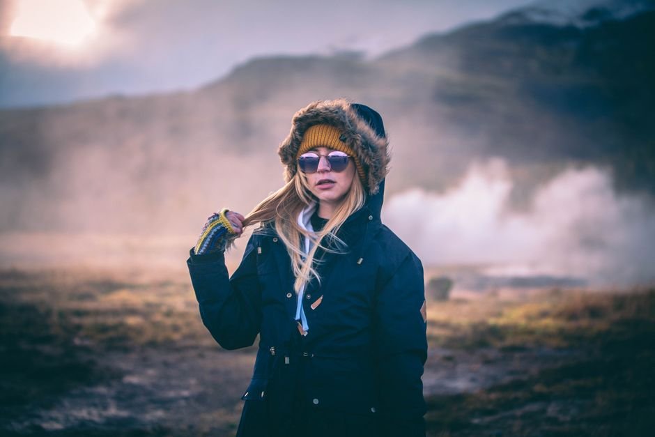 Mujer con parka en paisaje islandes entre niebla