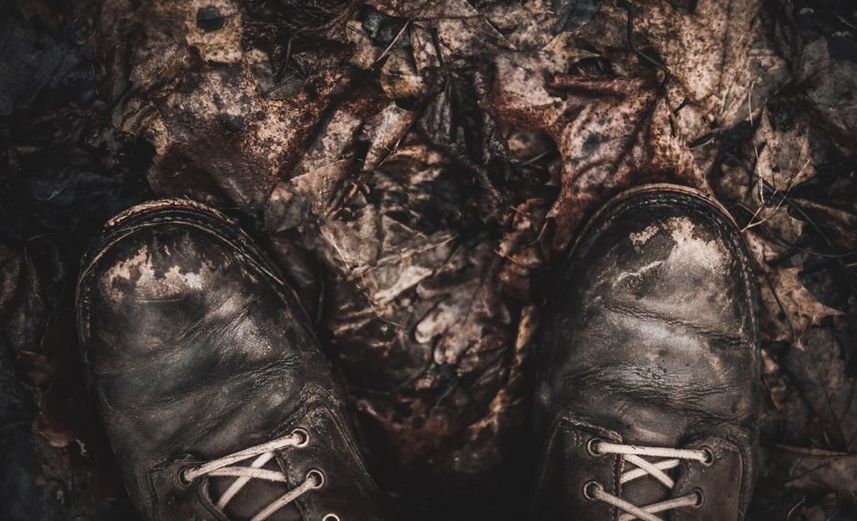 Botas de senderismo sobre hojas secas en sendero otonal
