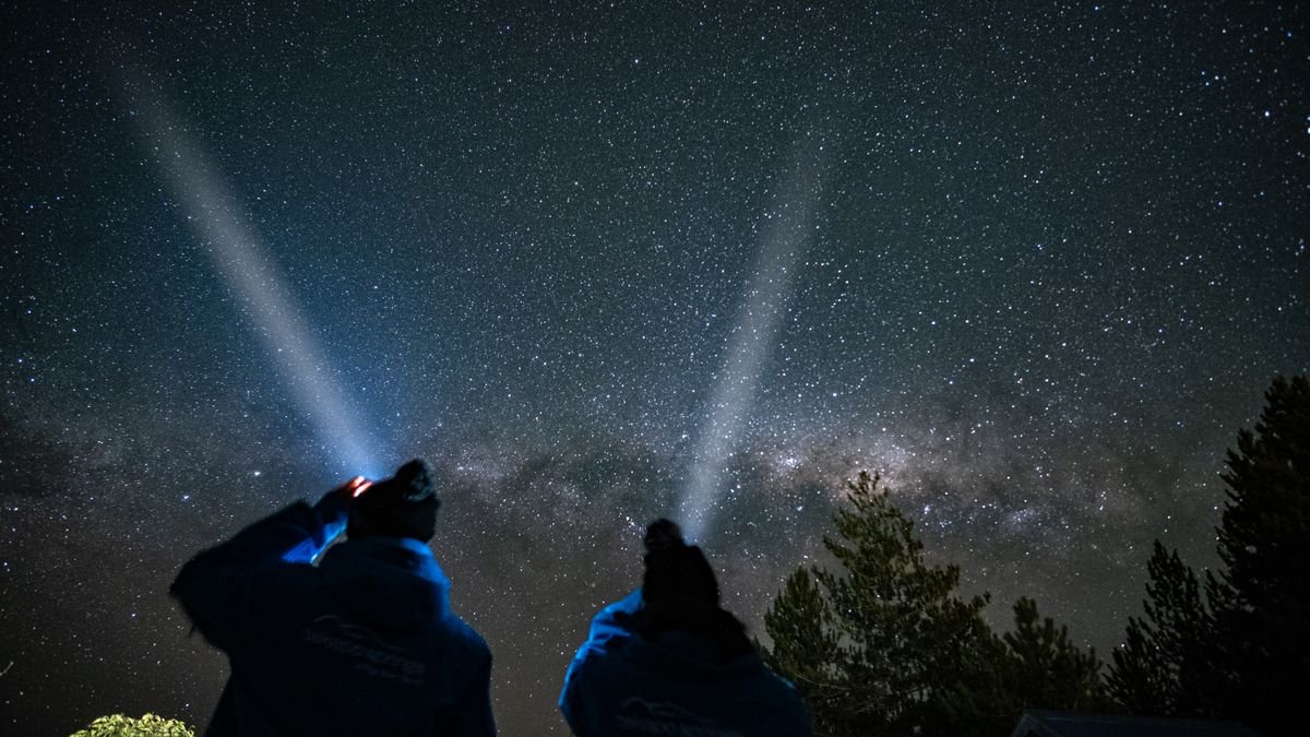 Dos personas observando una lluvia de estrellas en el campo