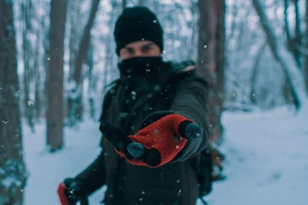 Persona con guantes térmicos de invierno en un bosque nevado