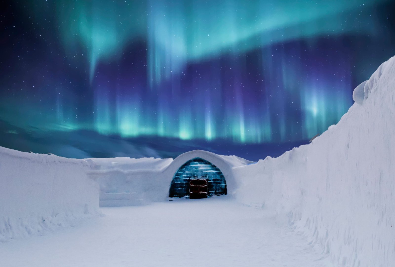 Iglú de cristal bajo la aurora boreal en un paisaje nevado