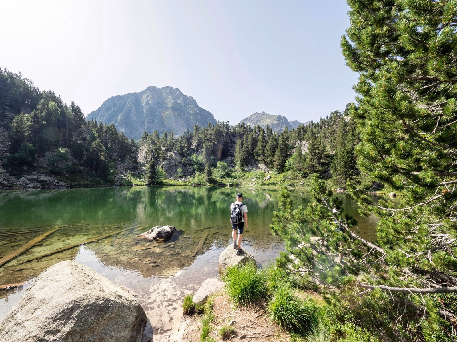 Senderista contemplando un lago de montaña en el Parque Nacional de Aigüestortes
