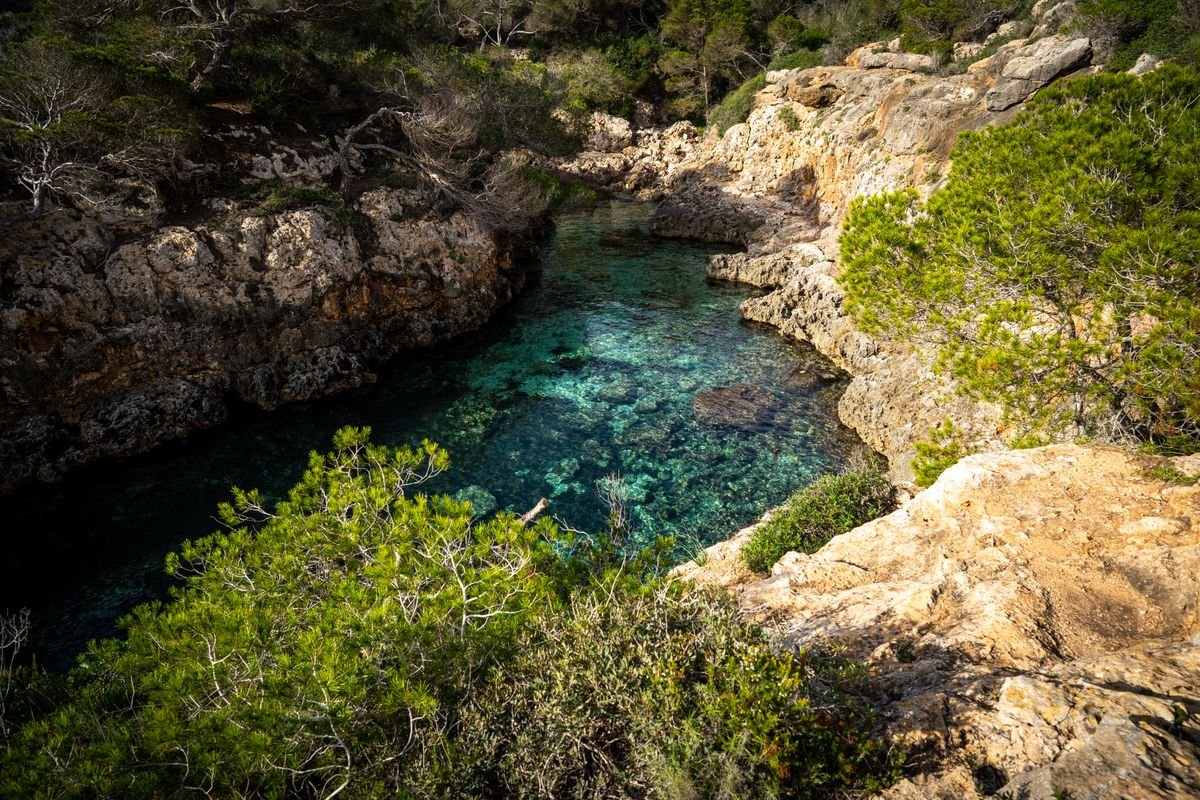 Cala de aguas turquesas rodeada de acantilados rocosos en la Costa Brava