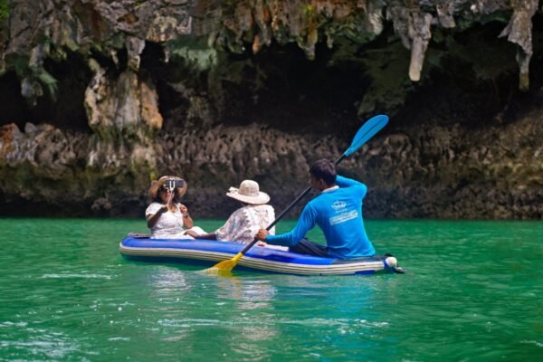 Familia remando en un kayak inflable de travesía por aguas turquesas