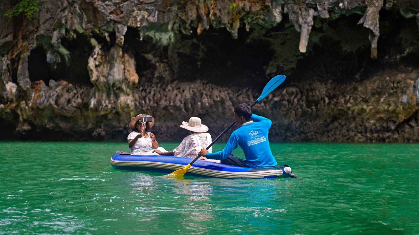Familia remando en un kayak inflable de travesía por aguas turquesas