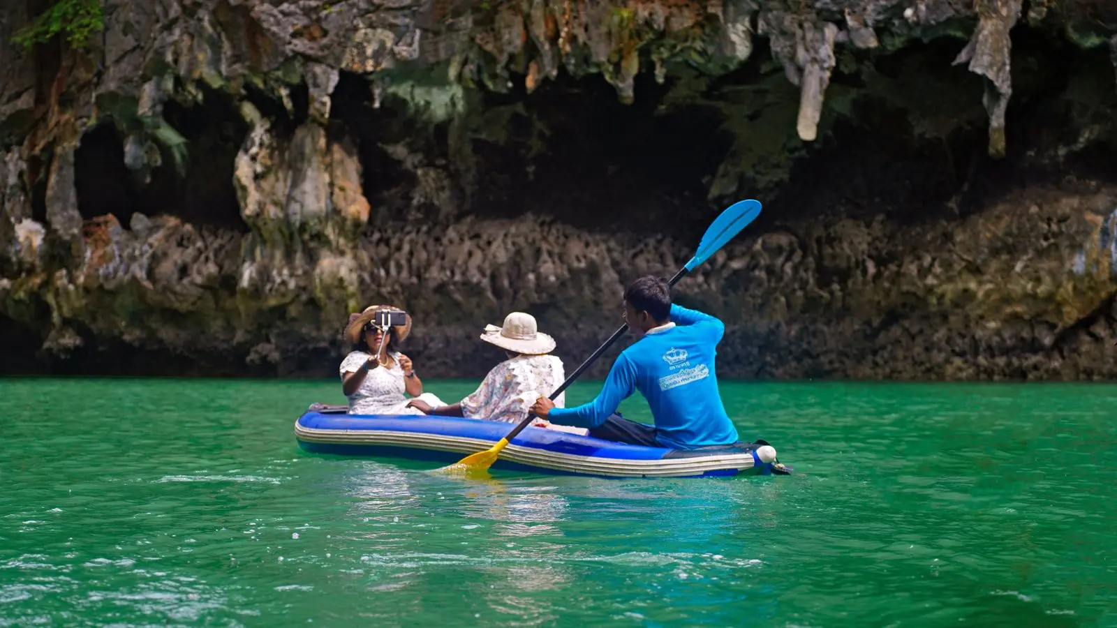 Familia remando en un kayak inflable de travesía por aguas turquesas