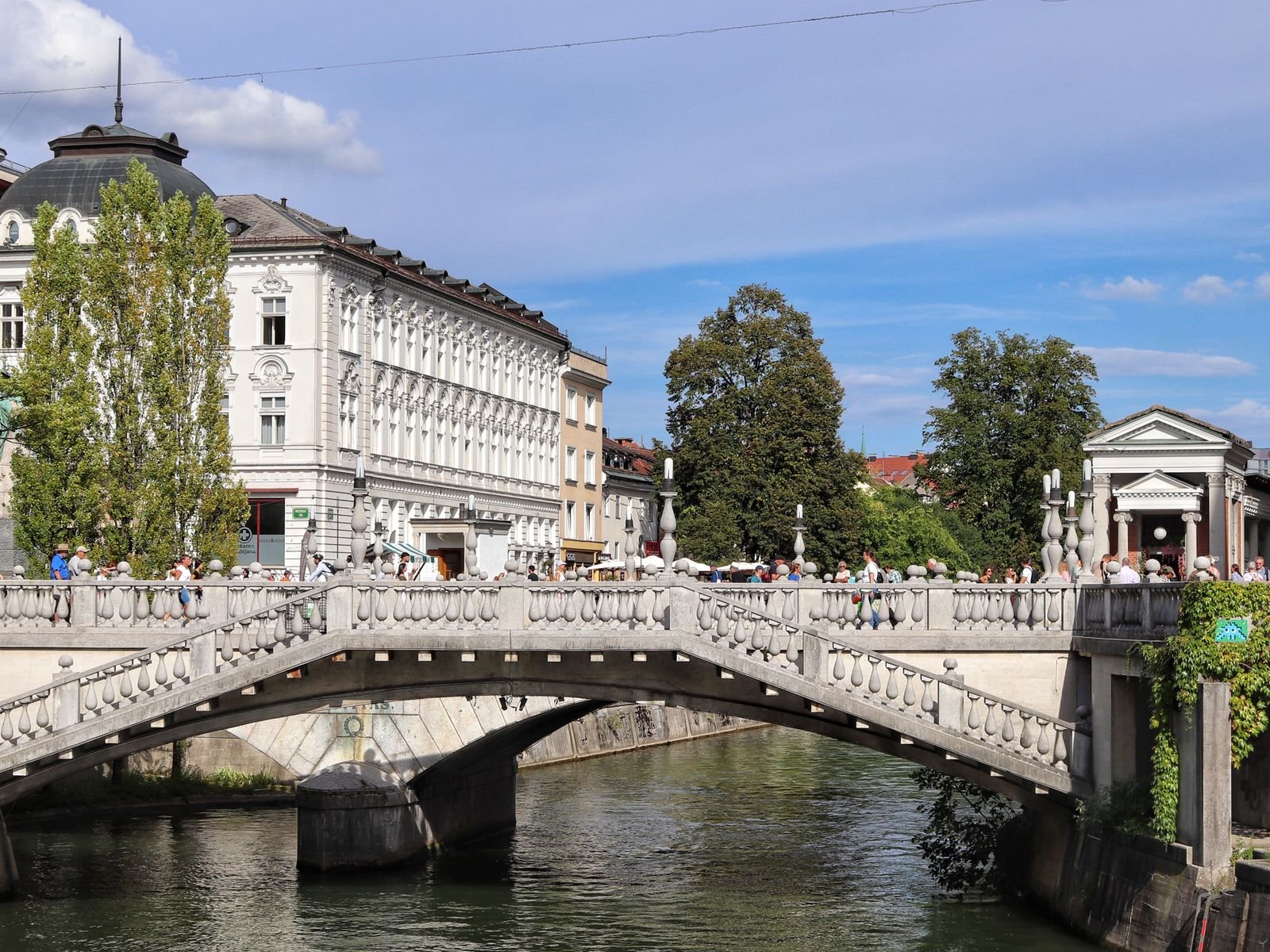 Puente Triple de Ljubljana con paseantes en un día soleado