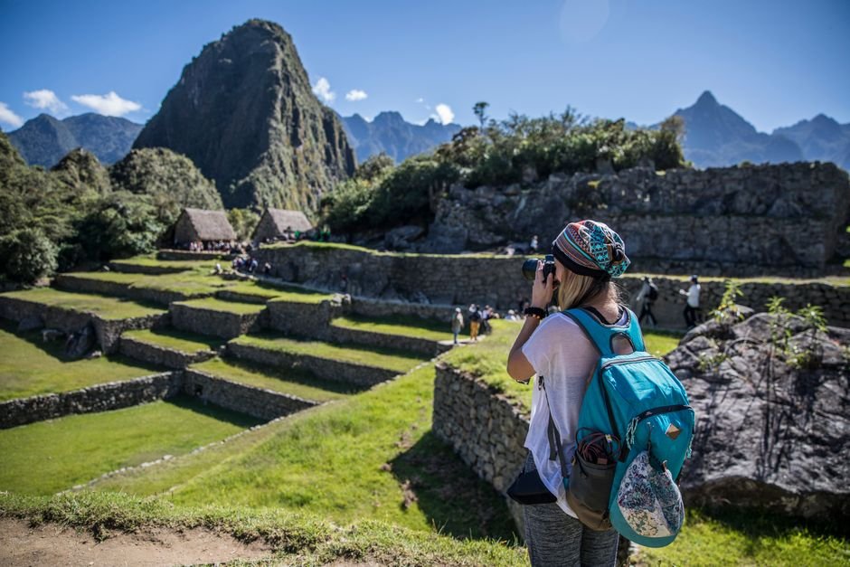 Una viajera captura la belleza de Machu Picchu en un día soleado en Perú.