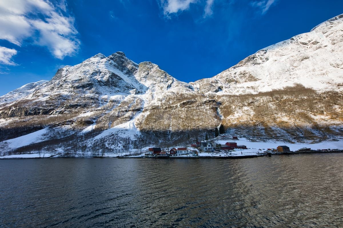 Montañas cubiertas de nieve reflejadas en aguas tranquilas de Aurland, Noruega
