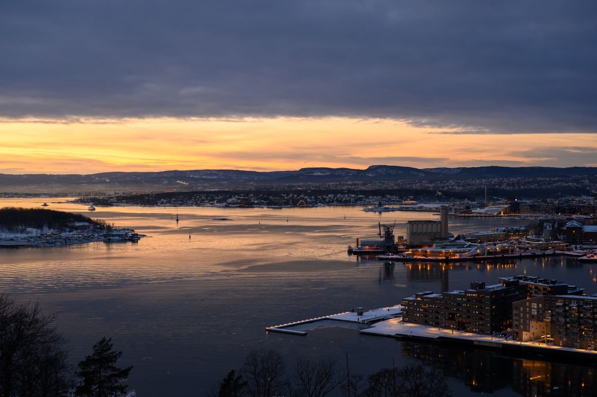 Vista aérea del fiordo de Oslo al atardecer con el horizonte de la ciudad