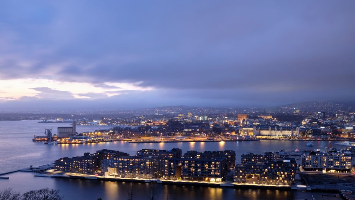 Horizonte de Oslo al anochecer con las luces de la ciudad reflejándose en el agua