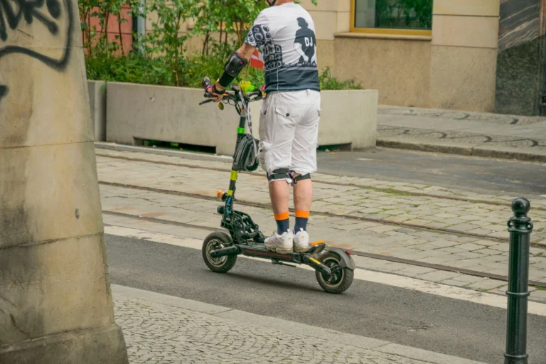 Persona usando un patinete eléctrico plegable por la ciudad