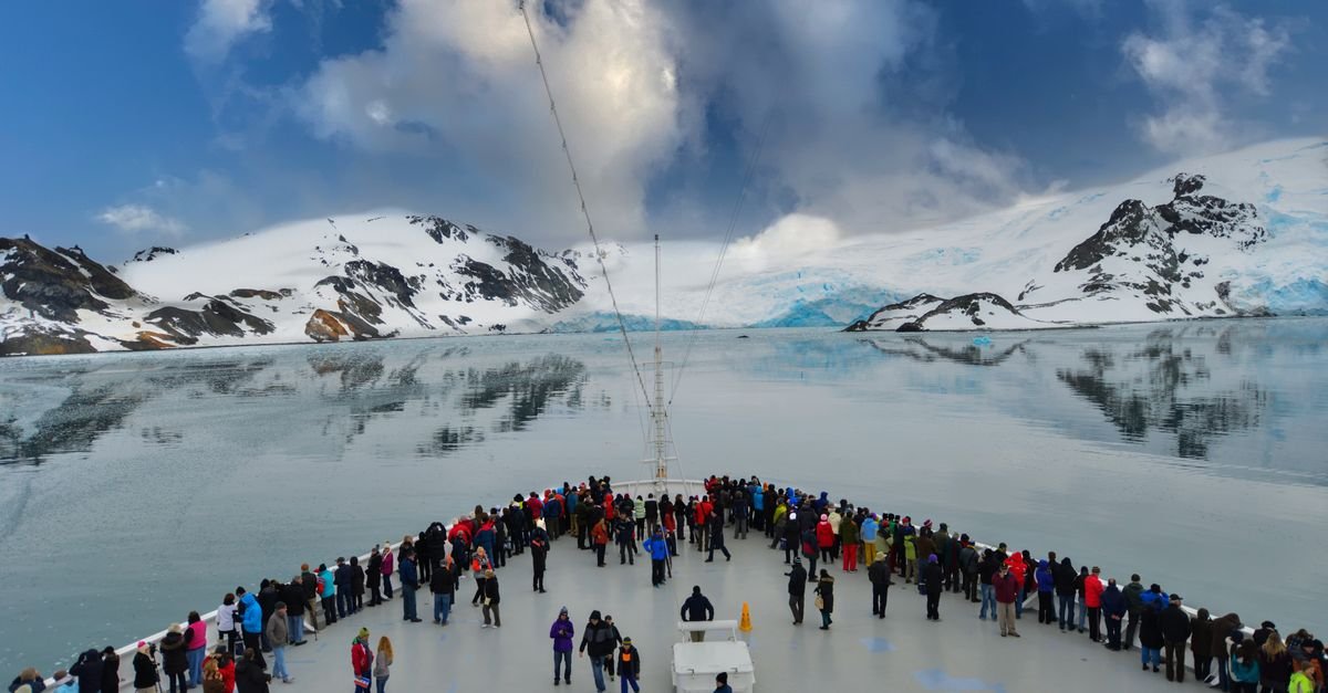 Barco de expedición frente a imponentes icebergs en la Antártida