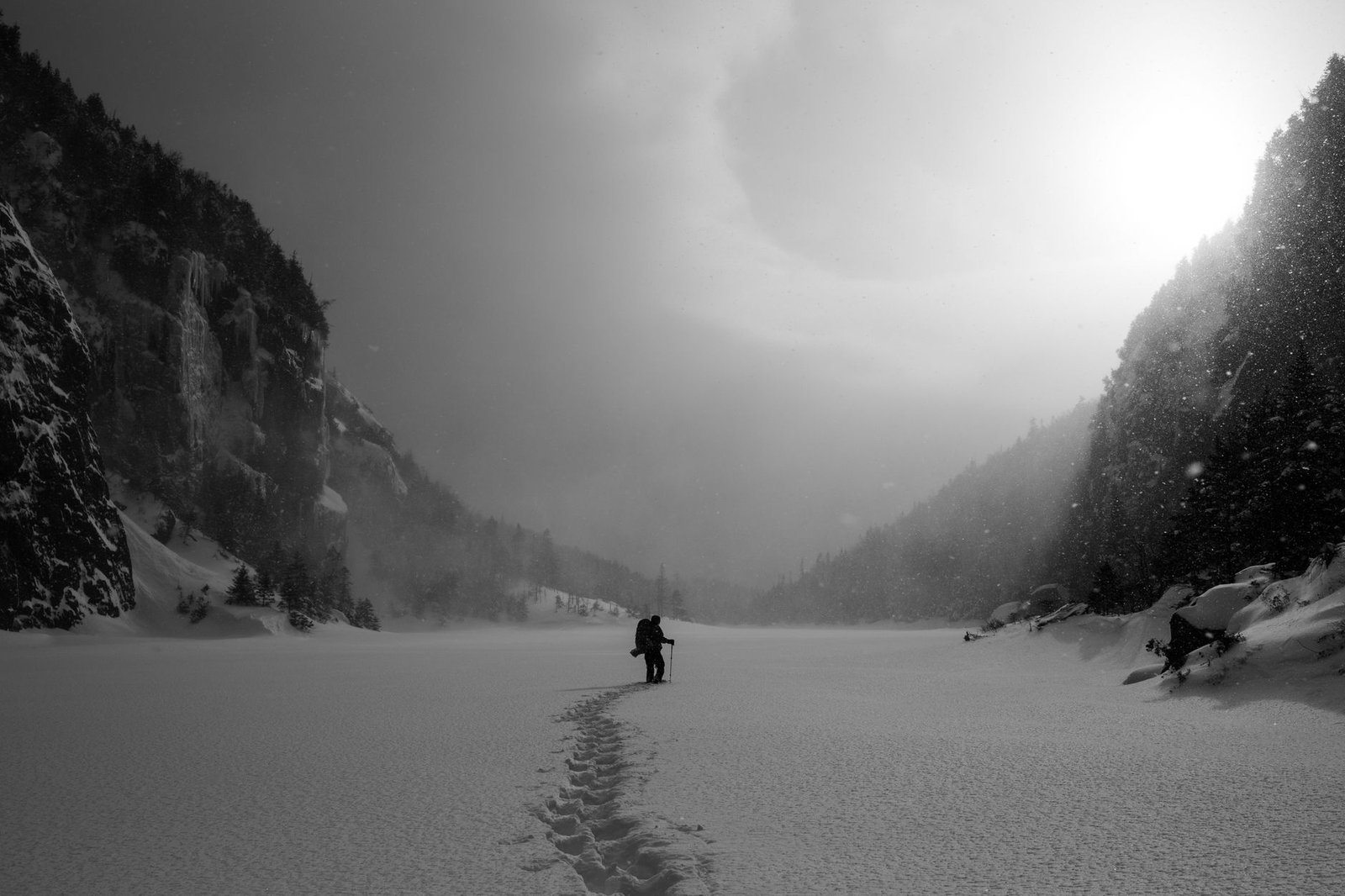 Excursionista avanzando por nieve profunda en un entorno de montaña invernal