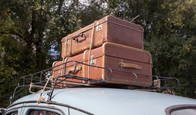 Maletas sujetas en la baca del techo de un coche antiguo preparado para un viaje por carretera