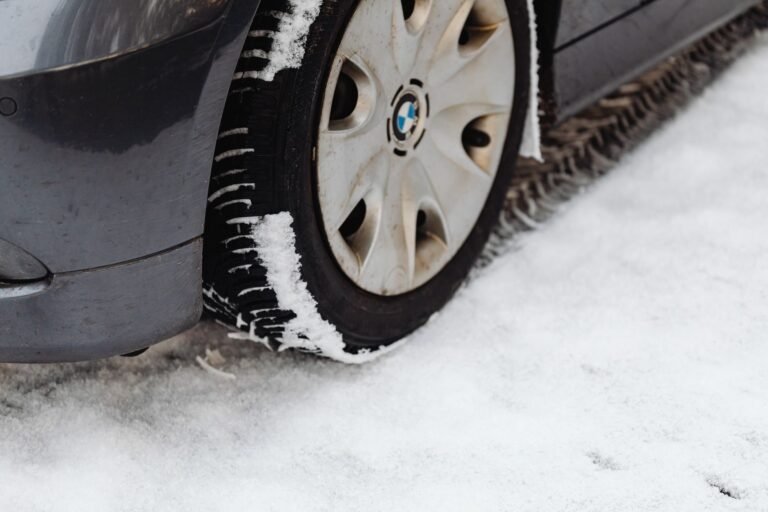 Primer plano del neumático de un coche sobre una carretera nevada de montaña en invierno