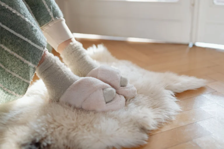 Zapatillas de viaje cómodas y calcetines sobre una alfombra suave