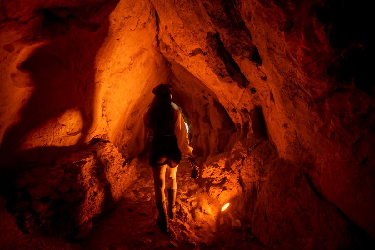 Exploradora con frontal recorriendo una cueva en España