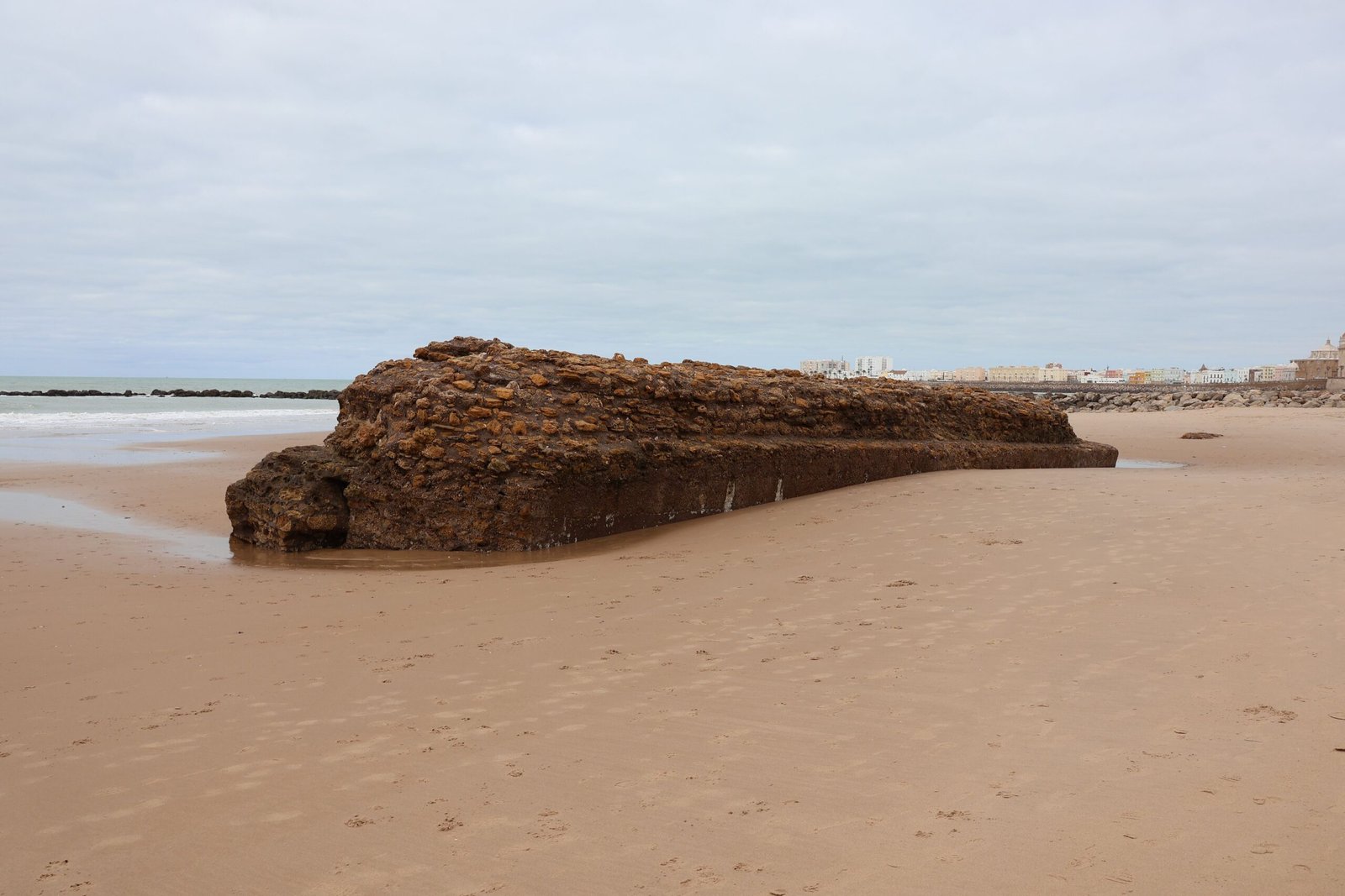 Playa de Cádiz con la muralla medieval y el casco histórico al fondo en un día de verano